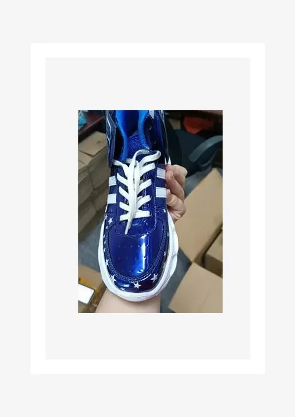 A person is holding onto the bottom of their blue sneakers.