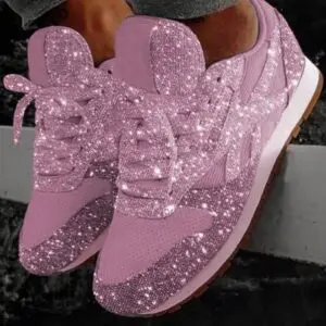 A pair of pink sneakers with sparkles on them.