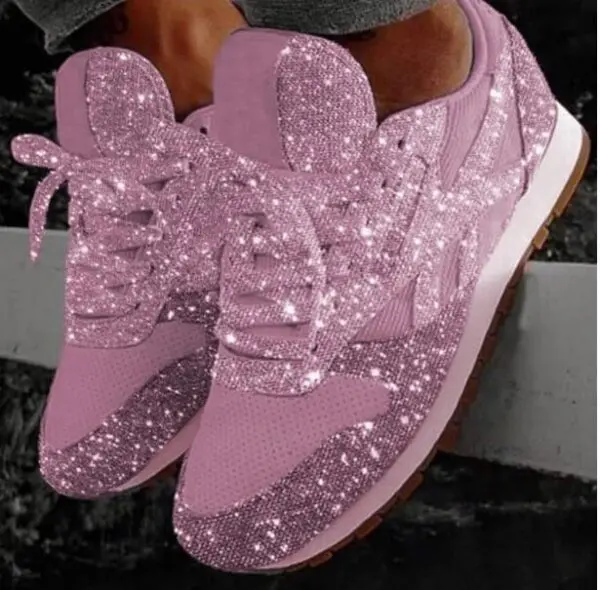 A pair of pink sneakers with sparkles on them.