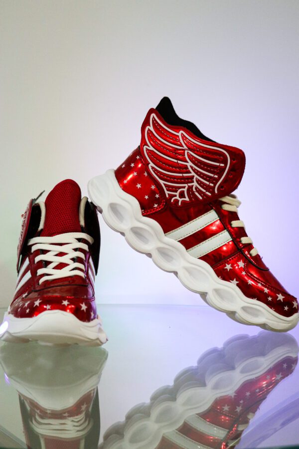 A pair of red sneakers with wings on them.